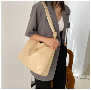 Model wearing large beige PU leather tote bag showing spacious design and soft texture