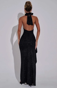 Détail du dos d'une robe noire à paillettes avec un grand nœud et une coupe dos nu chic