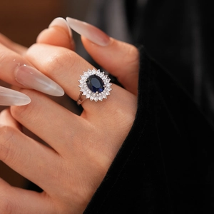 Detailed close-up of a hollow diamond-shaped flower ring with a large blue oval zircon stone