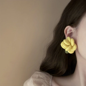 Elegant yellow flocked flower stud earrings for women shown on model's ear
