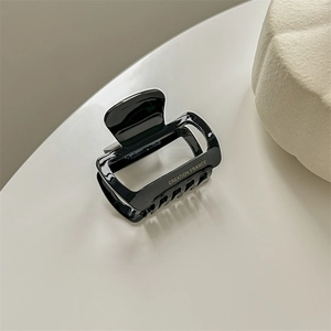 Detail of black acetate hair claw clip featuring polished finish and Creation France text