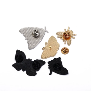 Vue détaillée du dos des broches papillon vintage montrant les fermoirs en métal sûrs
