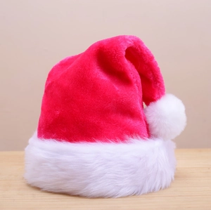 Detailed view of a soft plush red and white Christmas hat on a light wood surface