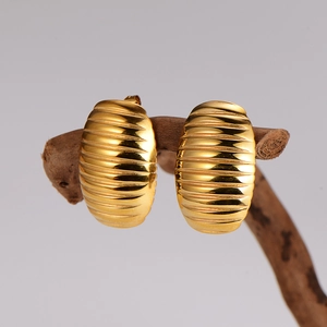 Vintage striped oval stud earrings in gold finish hanging on a natural wooden branch