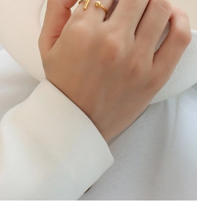 Detailed close-up of 18k gold-plated titanium steel open ring with ball and bar design