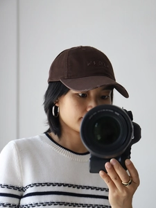 Close-up of MISTER embroidery and distressed ripped details on a dark brown baseball cap