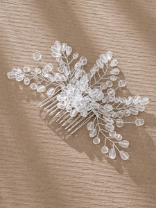 Macro shot of silver bridal hair comb with handmade crystal beads and floral leaf motifs