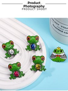 Detailed set of 5 cute frog enamel pins with colorful gemstones on a white tray
