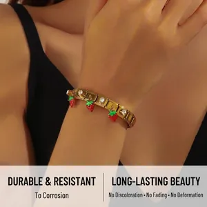 Detail view of gold strawberry charm bracelet with inlaid sparkling cubic zirconia