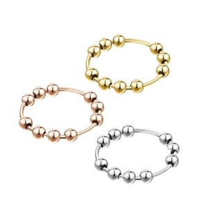 Detailed view of rotating bead anti-anxiety rings in gold, silver, and rose gold
