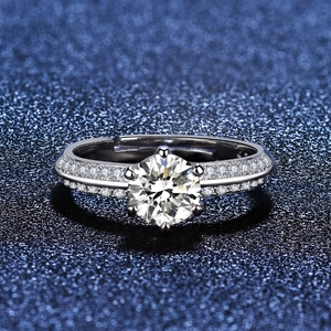 Macro shot of six-prong moissanite ring with pavé diamonds on a starry blue base