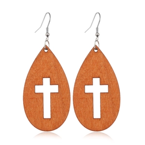 Detail of wooden teardrop earrings featuring a hollow cross design on a white background