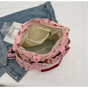 Detail of pink tote bag with cherry print showing inner pockets and zipper closure