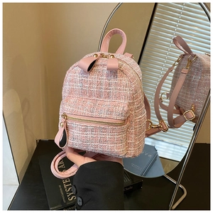Detailed macro view of pink tweed backpack texture with premium gold metal hardware