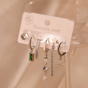 Detailed set of silver stainless steel earrings with green stones on a display card