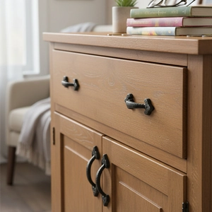 Retro black cast iron cabinet handles with hammered texture on a rustic wooden door