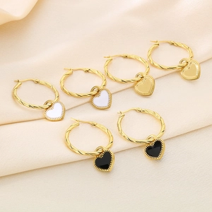 Detail of heart drop earrings featuring black and white enamel with twisted gold hoops