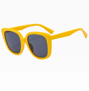 Detail view of the oversized bright yellow square frame sunglasses with dark lenses