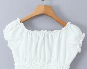 Detail of white square neck slim fit top featuring elastic ruched texture and puff sleeves
