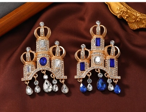 Detail of vintage palace style castle brooch with royal blue gems and tassels