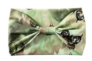 Detail of wide yoga headband featuring green tie-dye pattern and butterfly print with knot
