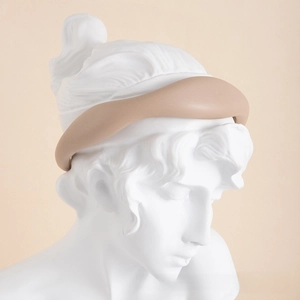 Close-up of khaki retro leather headband with thick padded design on a plaster model