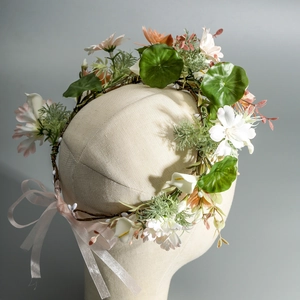 Close-up of handmade floral headband with calla lilies and ribbons on a mannequin