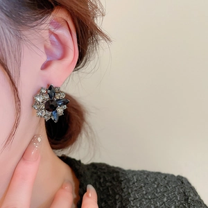 Detail view of retro flower earrings with black stones and sparkling crystal accents