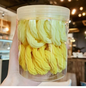 Detail of high-elasticity gradient hair ties stored in a transparent cylinder container