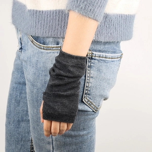 Detail view of dark grey knitted fingerless arm warmers showing texture and fit on a model