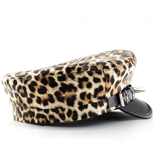 Detail of leopard print baker boy hat with punk silver studs and black leather brim