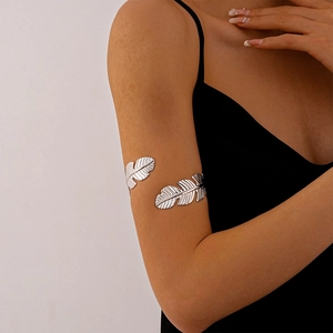 Detailed view of adjustable silver metal leaf upper arm cuff on model over black background
