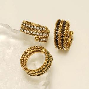Close-up of 18k gold plated multi-layer chain rings with green, black and white gems