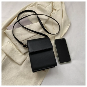 Petit sac bandoulière rectangulaire noir minimaliste avec téléphone pour comparer la taille
