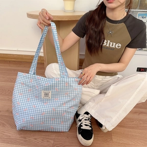 Detail of blue plaid canvas tote bag with pink bow pattern and large capacity design