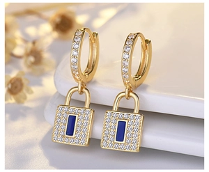 Close-up of golden s925 silver hoop earrings with diamond locks and blue center accents