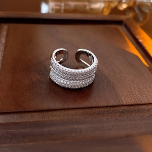 Detail eines silbernen doppelten offenen Rings mit Zirkonia auf einer dunklen Holzbox