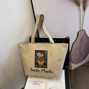 Detail of Santa Marta printed tote bag in beige linen material on a designer chair