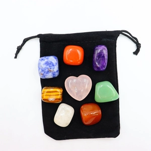 Polished seven-color rainbow crystal stones arranged on a black velvet storage pouch
