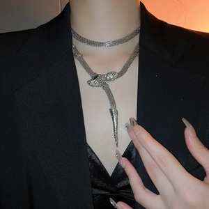 Detail of silver snake pendant necklace with green crystal eyes and rhinestone tassels