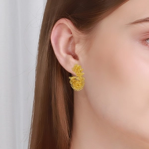 Detailed view of gold plated twisted coil earrings on model for a vintage fashion style