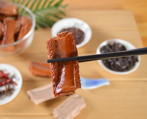 Detail eines realistischen PVC-Schweinerippchen-Schlüsselanhängers mit glänzender Soße