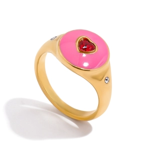 Detail of pink enamel heart ring with red center stone and 18K gold plated steel band