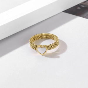 Detailed shot of gold mesh ring featuring a white heart shell inlay in a luxe style