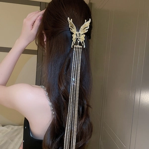 Vue arrière de la pince à cheveux papillon dorée avec de longs glands en strass brillants