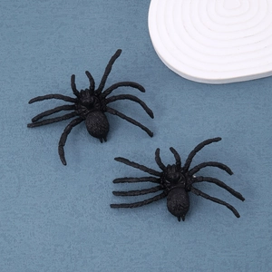 Detail shot of two realistic black spider stud earrings for Halloween accessories