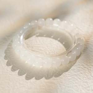 Detailed view of polished white chalcedony beaded bracelet with rhythmic soft shadows