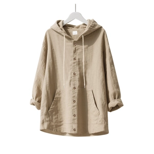 Close-up of beige linen hooded shirt showing crinkled cotton texture and pocket detail