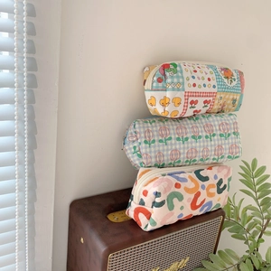 Tre pochette trapuntate a fiori impilate su un altoparlante vintage con luce soffusa
