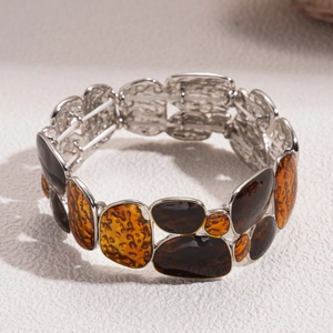 Macro detail of elastic wide bracelet with brown and gold geometric enamel inlays